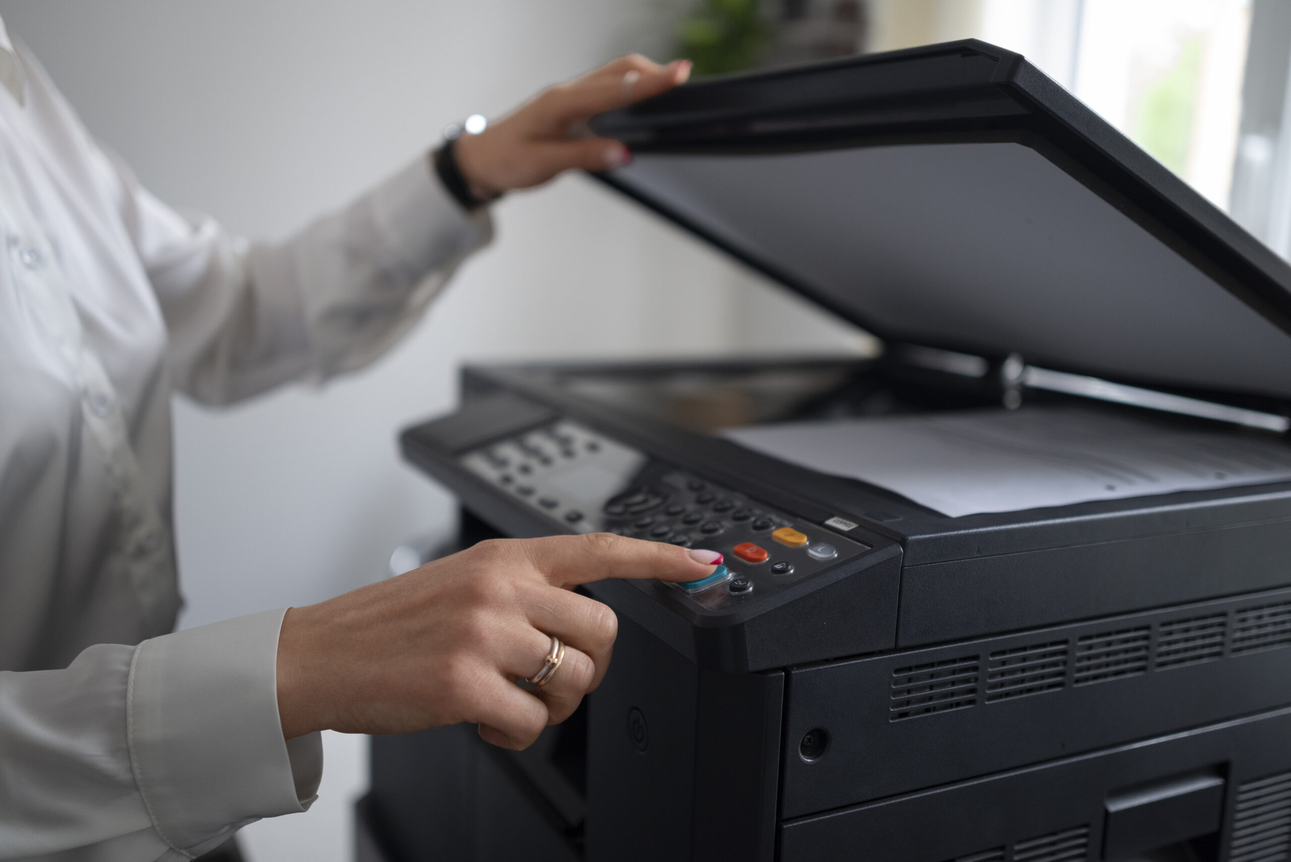 Side view of a person collecting freshly printed pages from a printer