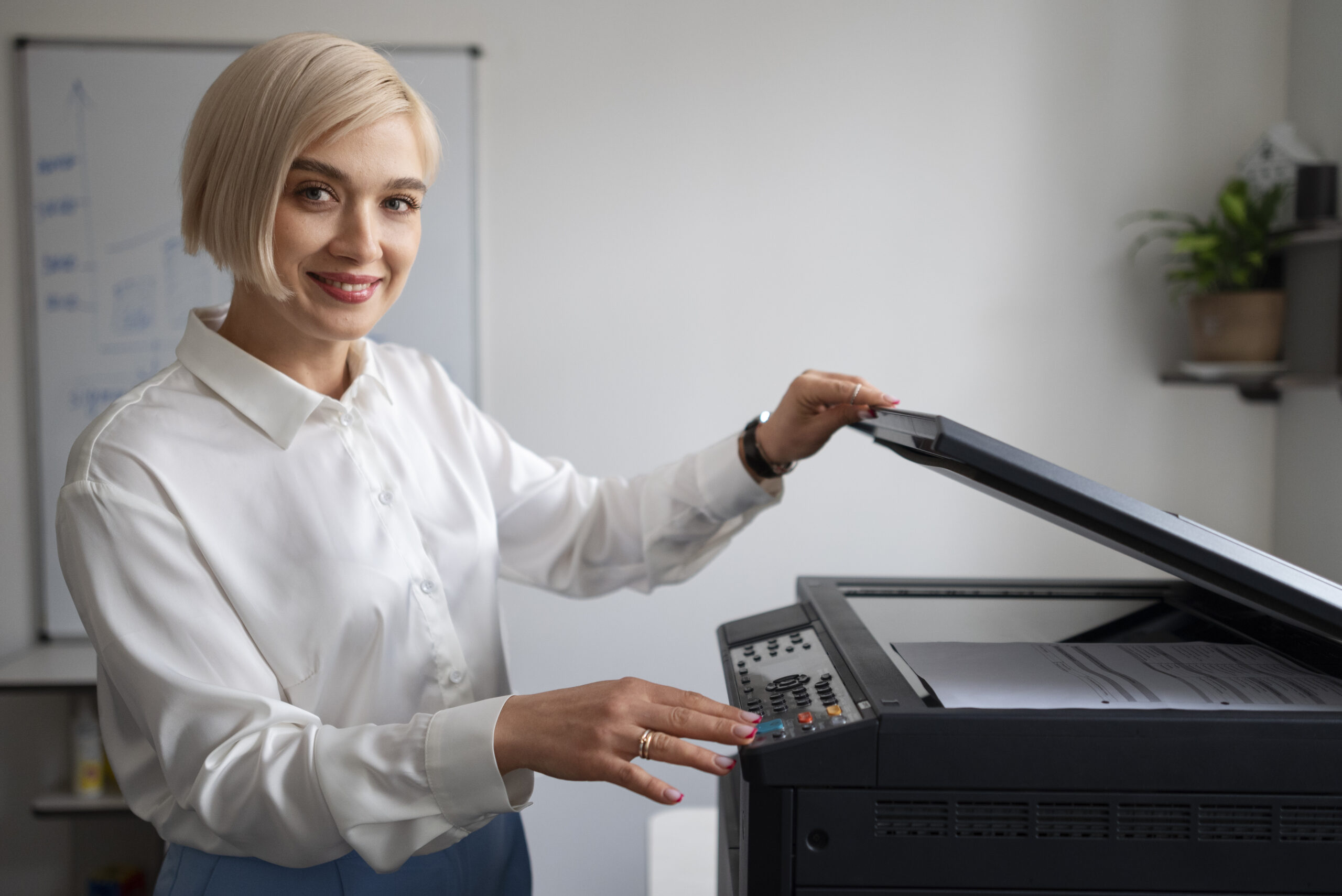 Woman operating an office printer near a desk